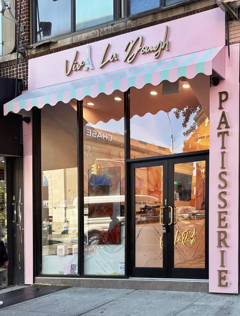 Borough Park storefront in powder pink, with a striped awning and gold Patisserie lettering