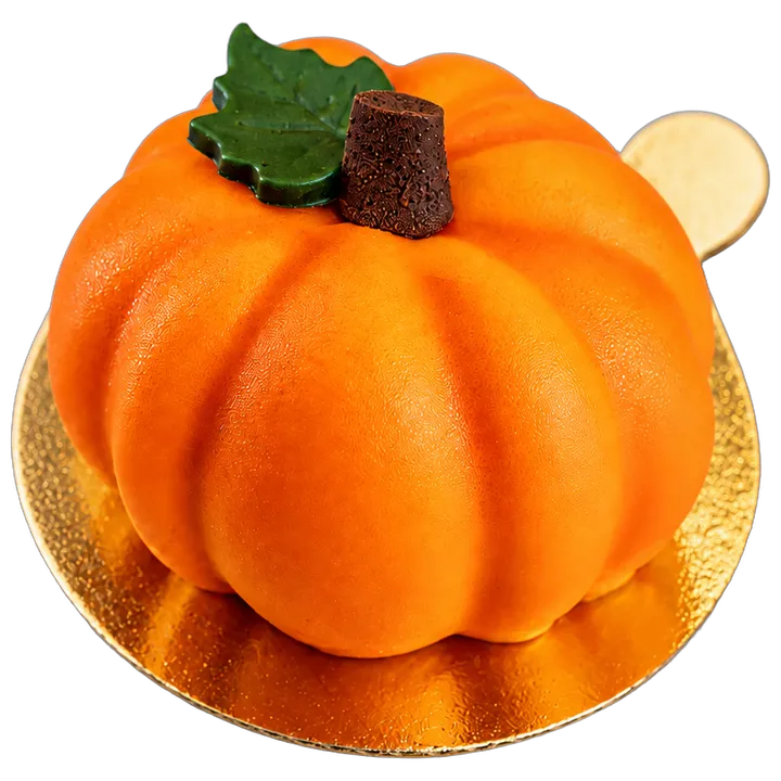 Pumpkin mousse cake, orange with a chocolate stem and a green leaf, on a gold board